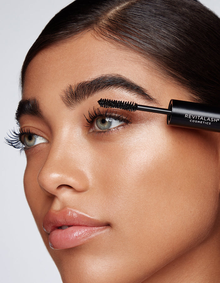 model applying Volumizing Mascara with brush