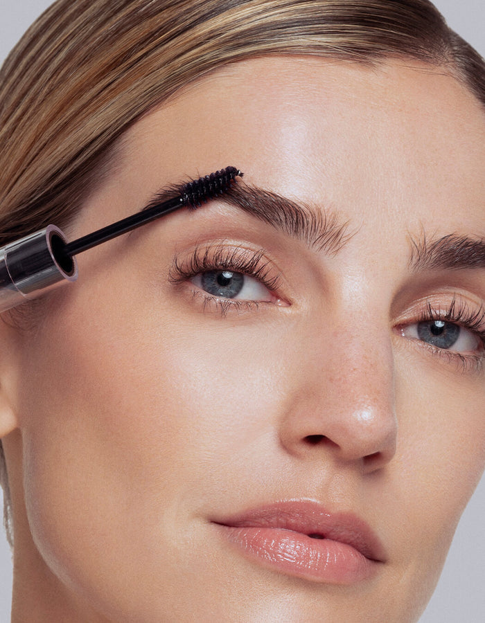 model applying Hi-Def Brow Gel with applicator