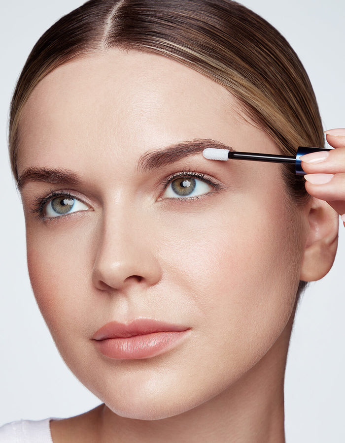 model applying brow serum